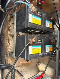 Twee zwarte VMF-Calcium accu's zijn zichtbaar, verbonden met kabels en geplaatst op een metalen rek.