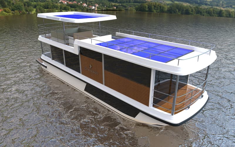 Een witte woonboot met zwarte en houten accenten, met zonnepanelen op het dak, drijft op water met een groene oever op de…