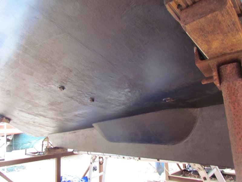 De onderkant van een boot, met een kiel en roestige steunen, staat op de wal. — Curtevenne 950 GSAK