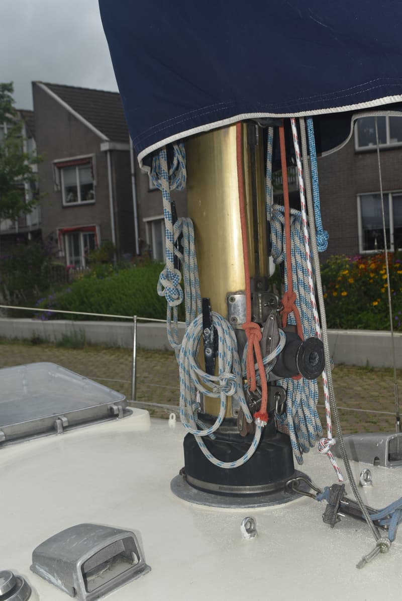 Een detailfoto van de mastvoet van een zeilboot met diverse lijnen en een donkerblauw zeil. — Frans Maas Raider 35