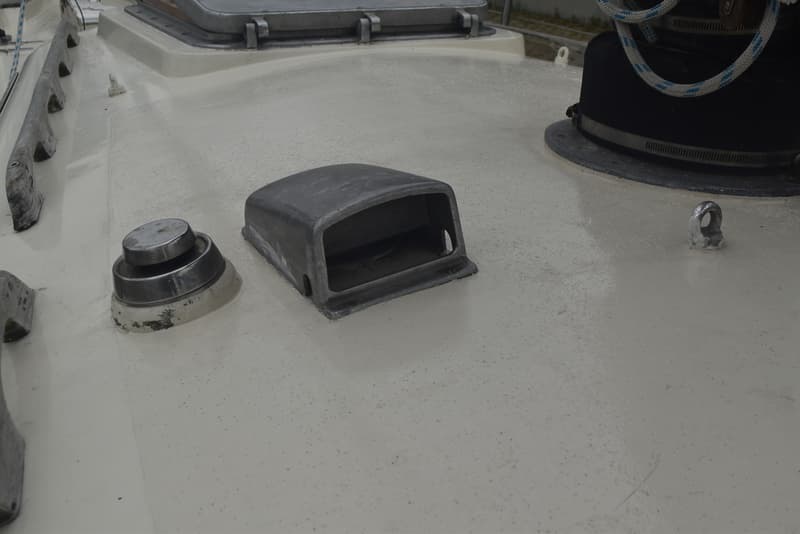 Een detail van het dek van een boot met een metalen ventilatiekap, een vuldop en een kikker. — Frans Maas Raider 35