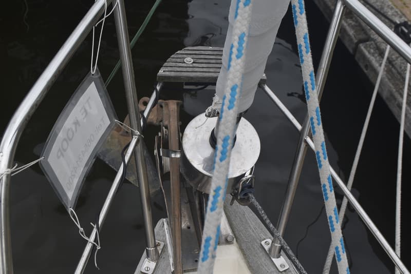 Een deel van de boeg van een zeilboot met een opgerold zeil, touwen en een "TE KOOP" bordje. — Frans Maas Raider 35