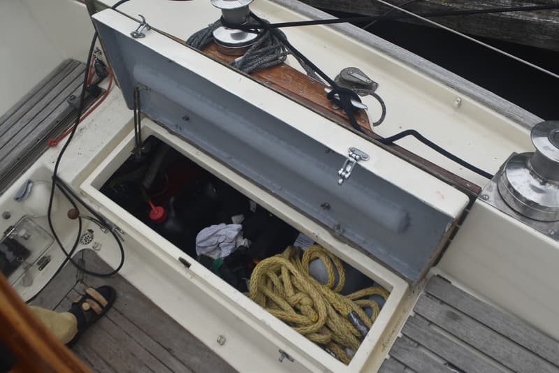 Een open opbergvak op een boot met daarin touwen en andere spullen, met een deksel dat openstaat. — Frans Maas Raider 35