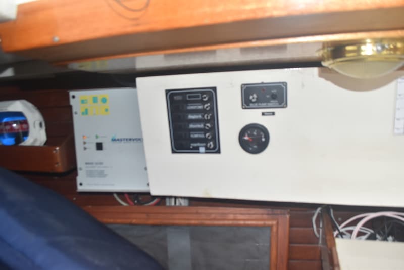 Een Mastervolt acculader en een bedieningspaneel met schakelaars en een meter zijn zichtbaar.