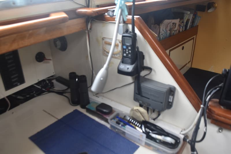 Een interieur van een boot met een marifoon, verrekijker, en diverse elektronica en opbergvakken. — Frans Maas Raider 35