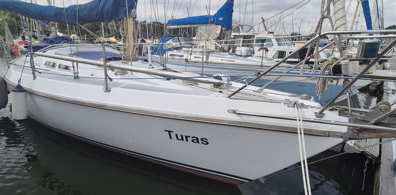 Een witte zeilboot met de naam "Turas" ligt afgemeerd in een haven. — Contest 36 Ketch