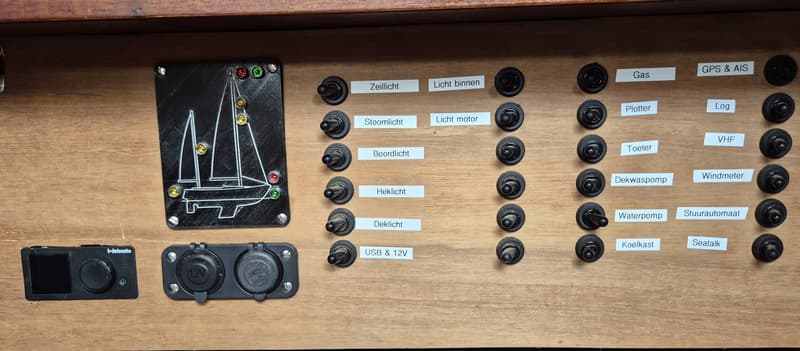 Een houten paneel met diverse schakelaars, een Webasto bedieningspaneel, 12V-aansluitingen en een schematische weergave van…