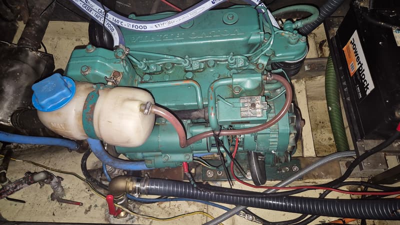 Een Volvo Penta scheepsmotor met een Powerblock accu, diverse slangen en bedrading.