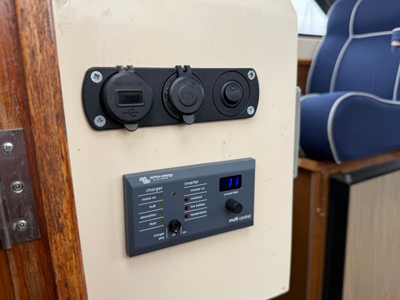 Een Victron Energy Multi Control paneel met een voltmeter, 12V-aansluiting en een schakelaar.