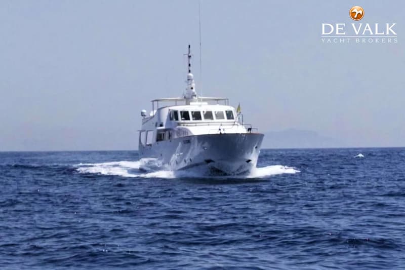 Een witte motorboot vaart over een blauwe zee, met een lichte lucht en bergen op de achtergrond. — CRN 120