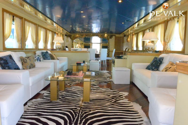 Een interieur van een boot met witte banken, een zebraprint vloerkleed en een blauw plafond. — CRN 120
