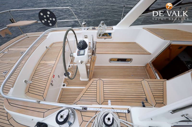 Een bovenaanzicht van de cockpit van een zeilboot met een houten dek, stuurwiel, navigatie-instrumenten en lieren. — Malo 37