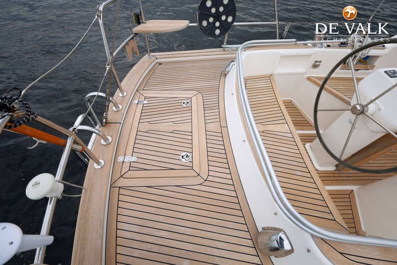 De foto toont een teakdek van een zeilboot met een stuurwiel en reling. — Malo 37