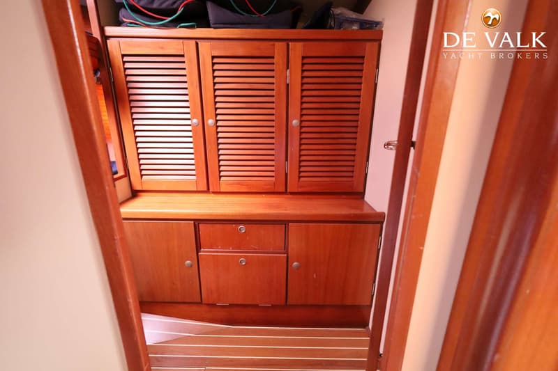 Een houten interieur met kasten en lades, en een gestreepte houten vloer.