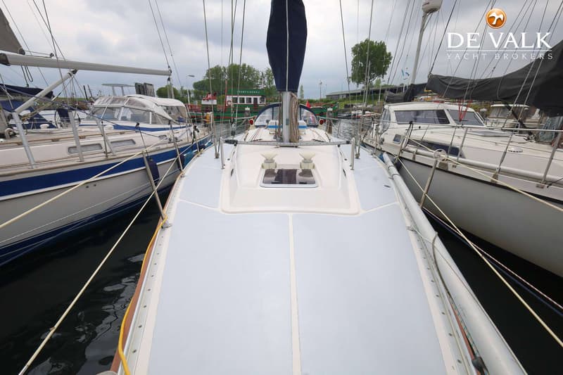 Een bovenaanzicht van het dek van een zeilboot, met een opgerold zeil en twee luiken. — Hanse 401