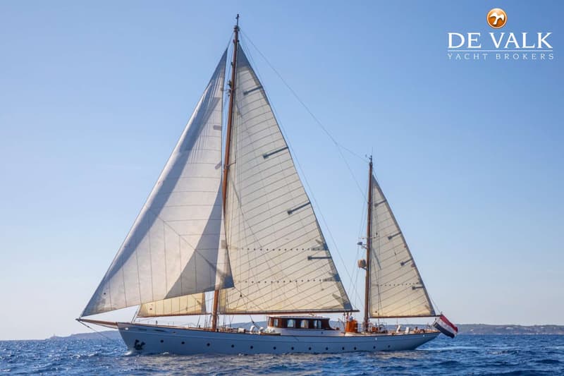 Een zeilboot met twee masten vaart op een helderblauwe zee onder een strakblauwe lucht. — Feadship Ketch
