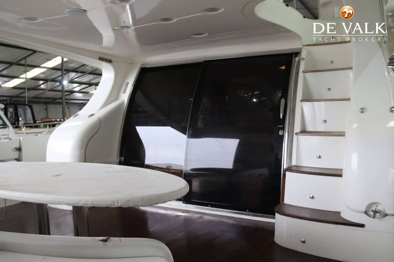 Een interieur van een boot met een ronde tafel, een trap en een schuifdeur. — Azimut 68 Plus