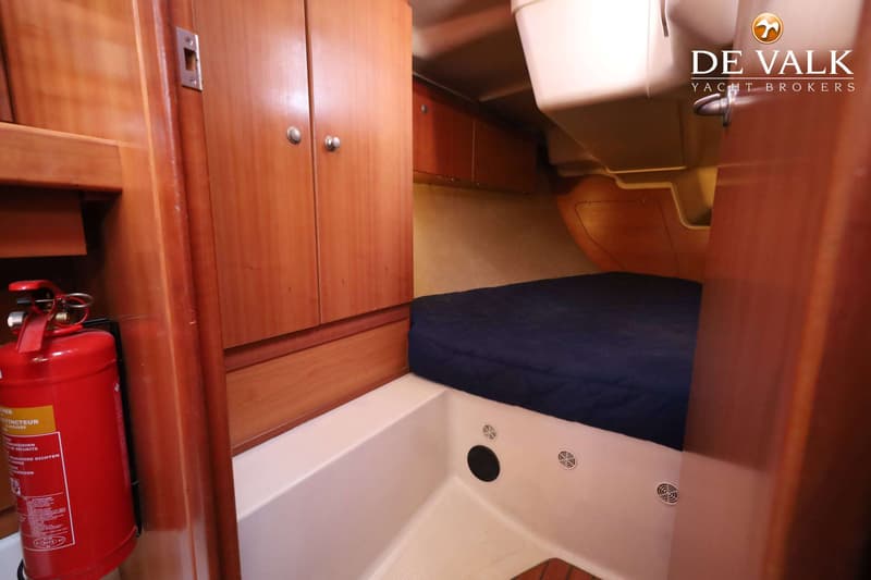 Een kajuit met een bed, houten kasten en een rode brandblusser. — Dehler 41 Cruising