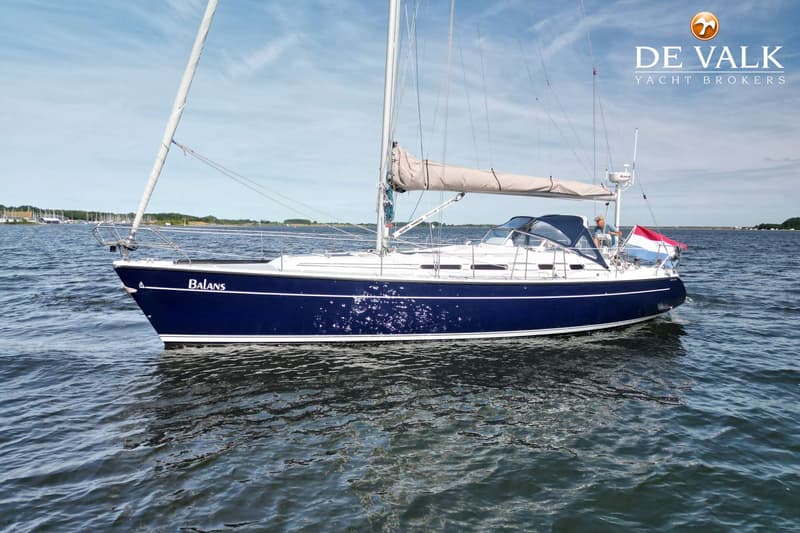 Een blauwe zeilboot met de naam "Balans" vaart op water onder een lichtbewolkte hemel. — Dehler 41 Cruising