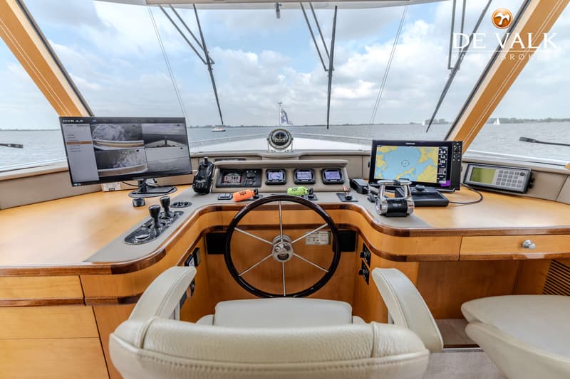 De foto toont de stuurhut van een boot met een stuurwiel, diverse schermen en bedieningspanelen. — Jetten Custom