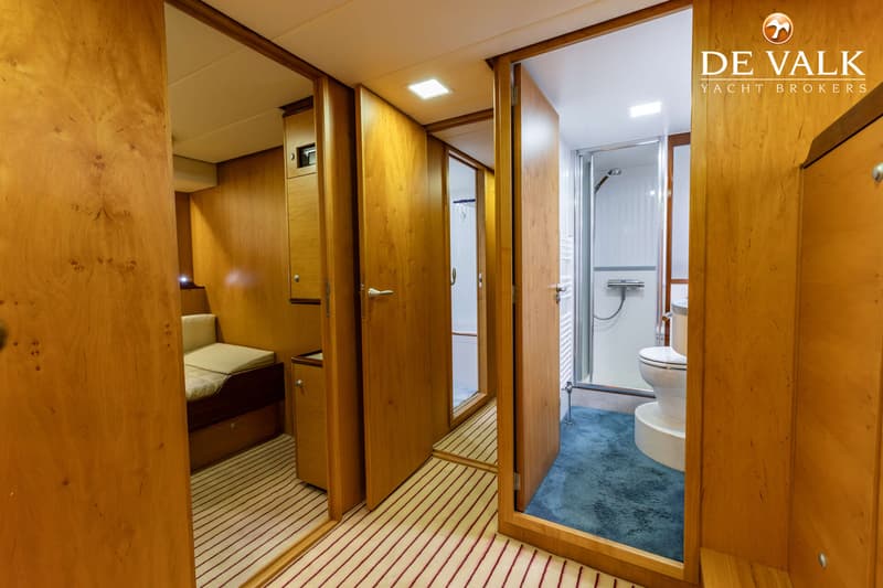 Een interieur van een boot met houten wanden en deuren, een bed, een toilet en een douchecabine. — Jetten Custom