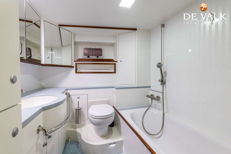 De foto toont een badkamer met een wastafel, toilet en bad met douchekop.