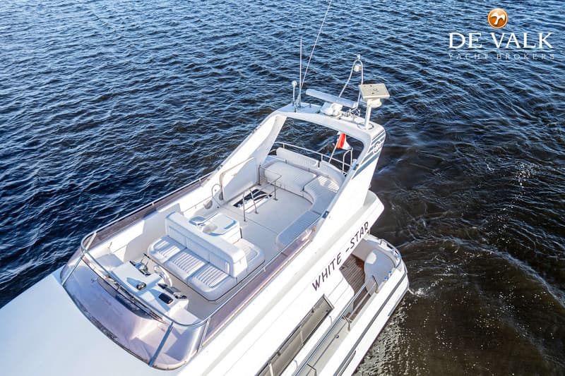 Een witte motorboot met de naam "WHITE-STAR" vaart op donkerblauw water, gezien van bovenaf. — Neptunus 156