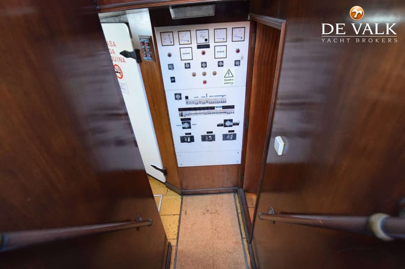 Een elektrische paneel met meters, schakelaars en een waarschuwingssymbool is zichtbaar tussen twee houten wanden met…