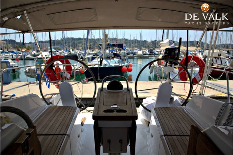 Een achteraanzicht van een zeilboot met twee stuurwielen, uitkijkend over een jachthaven vol met boten. — Bavaria 37 Cruiser
