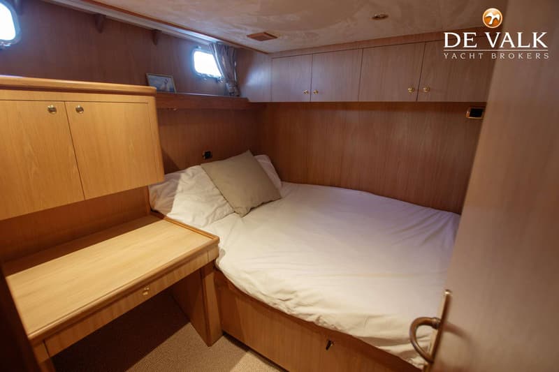 Een kajuit met een bed, een bureau, kasten en twee patrijspoorten. — Kompier Canoe Stern 1650 Trawler
