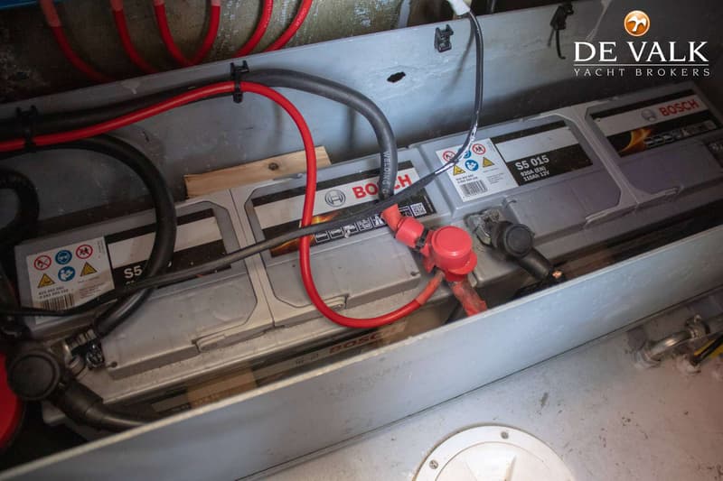 Twee Bosch S5 015 accu's van 110Ah 12V zijn zichtbaar, verbonden met rode en zwarte kabels.
