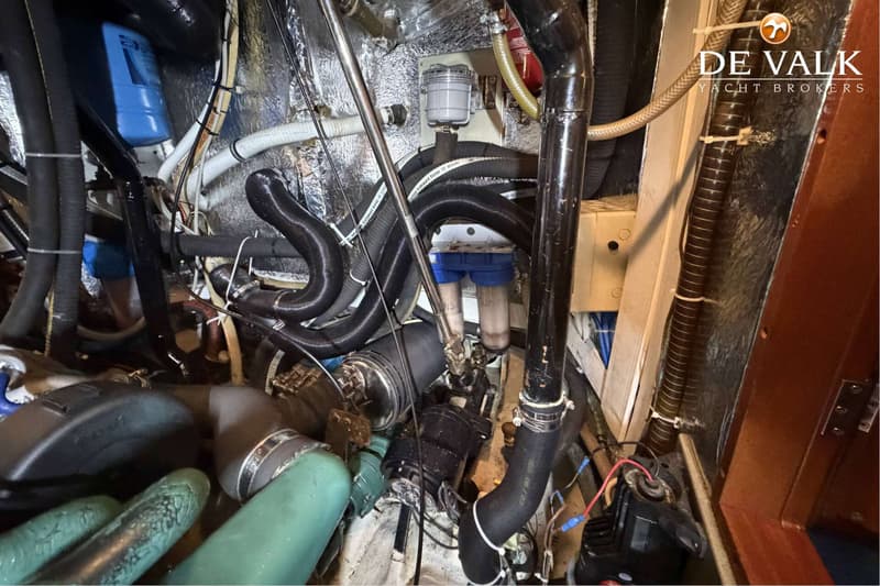 Een detailfoto van de motorruimte van een boot met diverse slangen, leidingen, filters en bedrading. — Hallberg Rassy 46