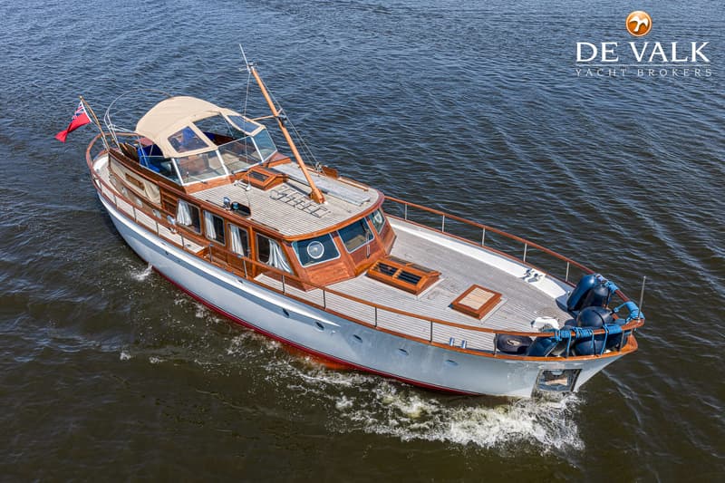 Een witte motorboot met houten opbouw en dek vaart op donkerblauw water. — Kok Spitsgatkotter 16.50