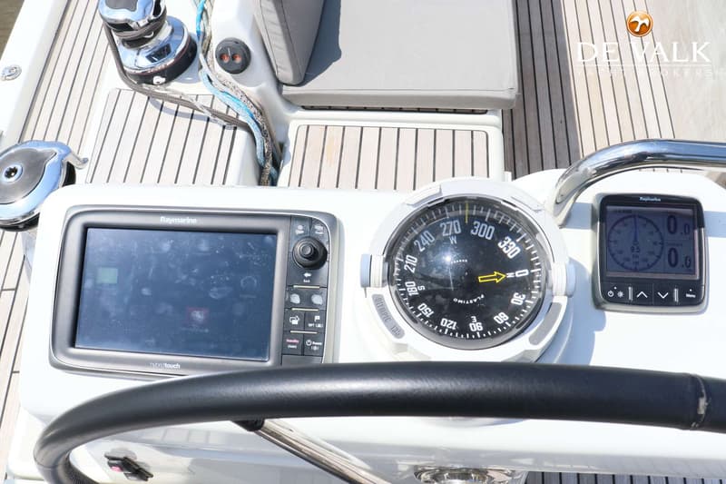 Een stuurstand met een Raymarine kaartplotter, een kompas en een Raymarine display, met een stuurwiel op de voorgrond.