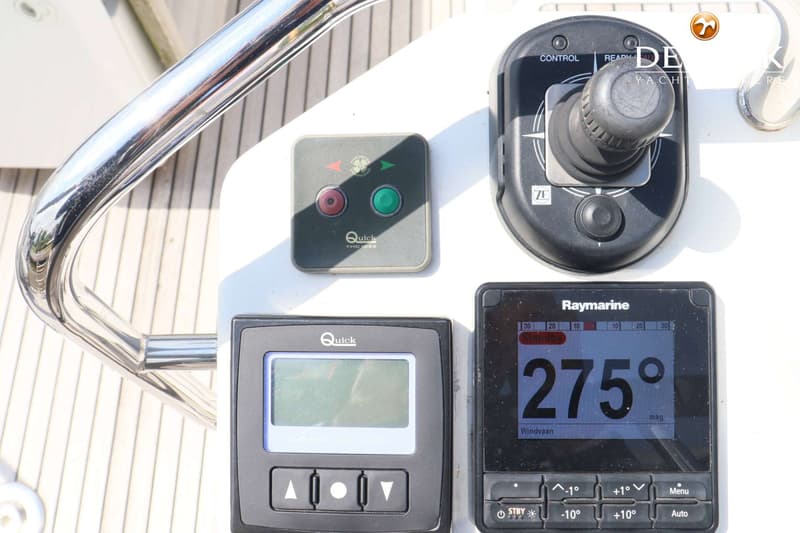 De foto toont een close-up van diverse navigatie- en bedieningspanelen op een boot, waaronder een joystick, een Raymarine…