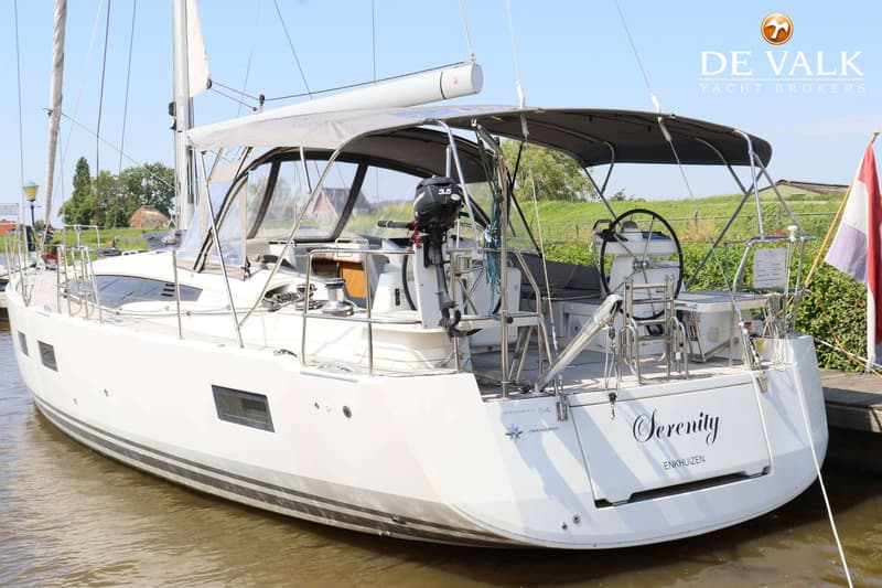 Een witte zeilboot met de naam "Serenity" en "ENKHUIZEN" op de spiegel, ligt aangemeerd aan een steiger. — Jeanneau 54