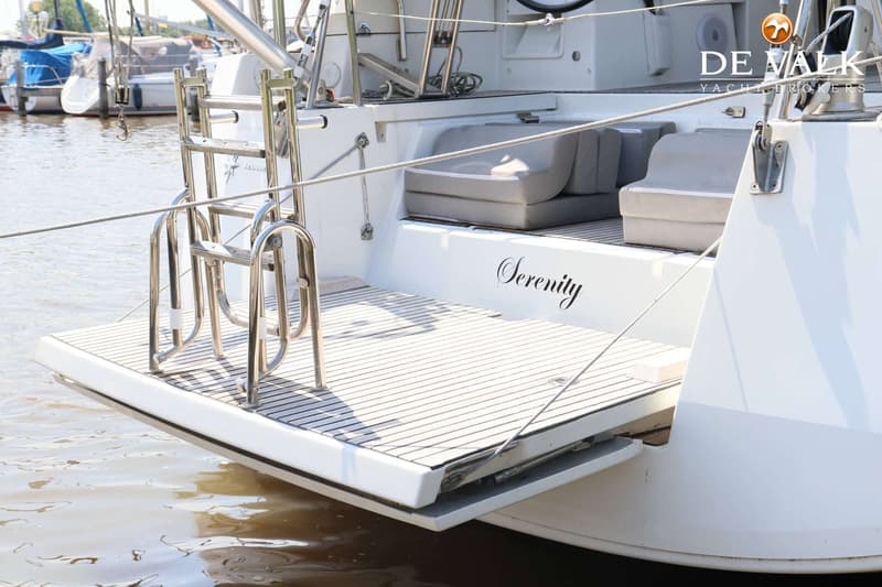 Een witte boot met een zwemplateau, een zwemtrap en de naam "Serenity" op de spiegel. — Jeanneau 54