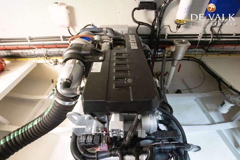 Een Vetus scheepsmotor met diverse slangen, kabels en filters is zichtbaar in een motorruimte.