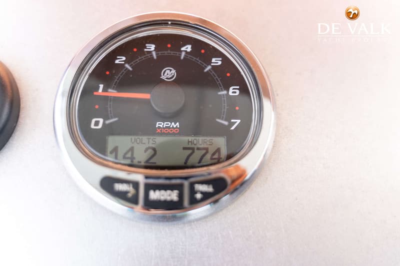 Een close-up van een Mercury toerenteller met een digitale display die 14.2 volt en 774 draaiuren weergeeft.