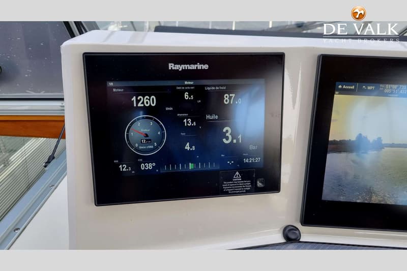 Twee schermen tonen navigatie- en motorinformatie, met een Raymarine-logo op het linkerscherm.