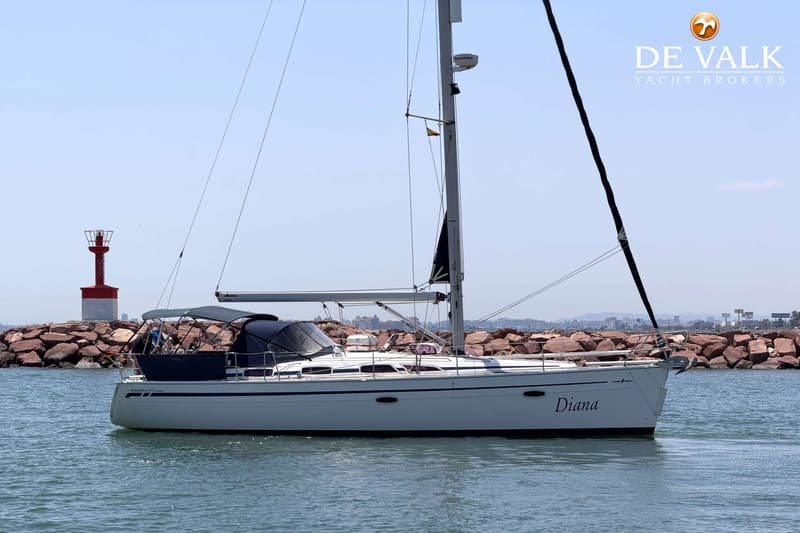Een witte zeilboot met de naam "Diana" vaart op water, met een vuurtoren en rotsen op de achtergrond. — Bavaria 40 Cruiser