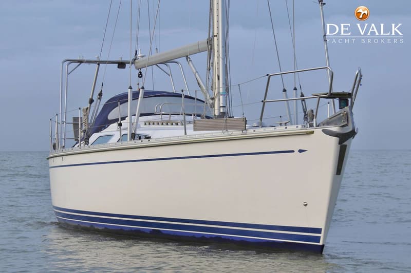 Een witte zeilboot met blauwe strepen op de romp en een blauwe buiskap ligt in het water. — Comfortina 42