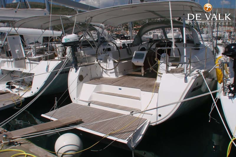 De achterkant van een witte zeilboot met een houten dek en een uitklapbaar zwemplateau. — Bavaria 46 Cruiser