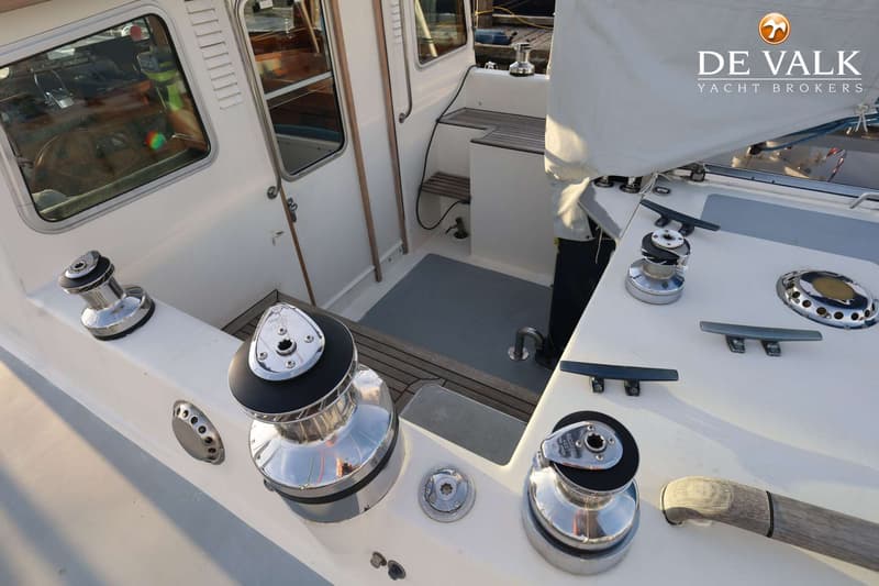 Een bovenaanzicht van het dek van een boot met lieren, bolders en een kajuitingang. — Robert Clark 64 Pilothouse