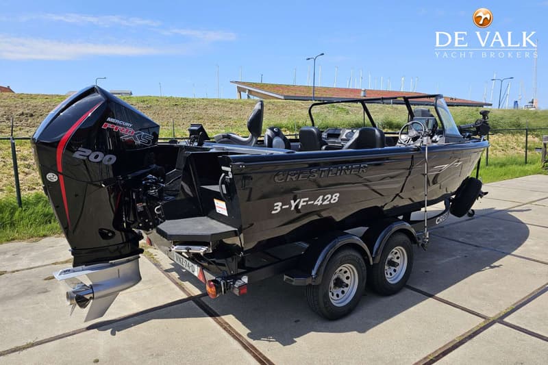 Een zwarte Crestliner boot met een Mercury Pro XS 200 buitenboordmotor staat op een trailer. — Crestliner Sportfish 2050