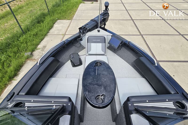 Een bovenaanzicht van de boeg van een boot met een visstoel, een tafel en twee banken. — Crestliner Sportfish 2050