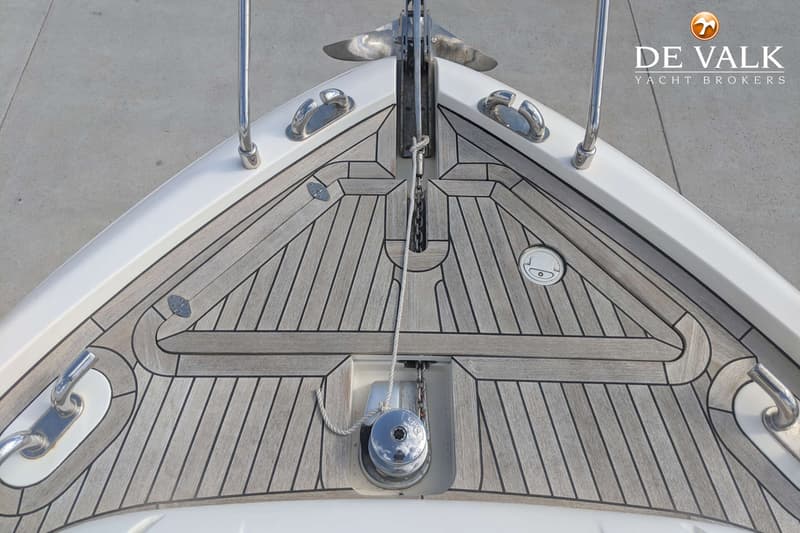 De foto toont de boeg van een boot met een teakhouten dek, ankerlier, anker en bolders. — Ferretti 510