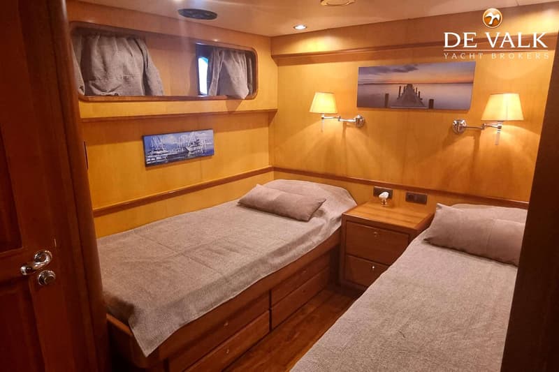 Een kajuit met twee eenpersoonsbedden, twee schilderijen, twee wandlampen en een nachtkastje. — Vripack 69 Expedition Trawler