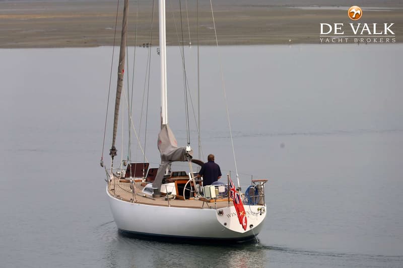 Een zeilboot met een man aan het roer vaart weg van de camera, met een Britse vlag aan de achtersteven. — Dick Zaal 41