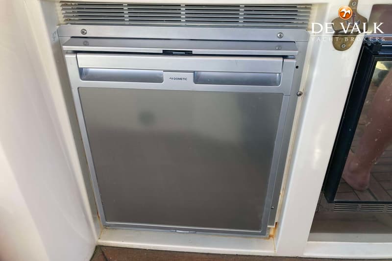 Een ingebouwde zilverkleurige Dometic koelkast met een ventilatierooster erboven.
